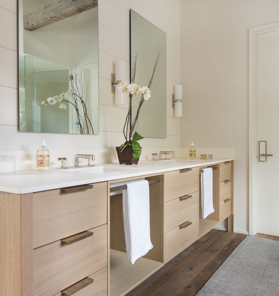 Immagine di una stanza da bagno padronale country con lavabo sottopiano, ante lisce, ante in legno chiaro, pareti beige e pavimento in legno massello medio