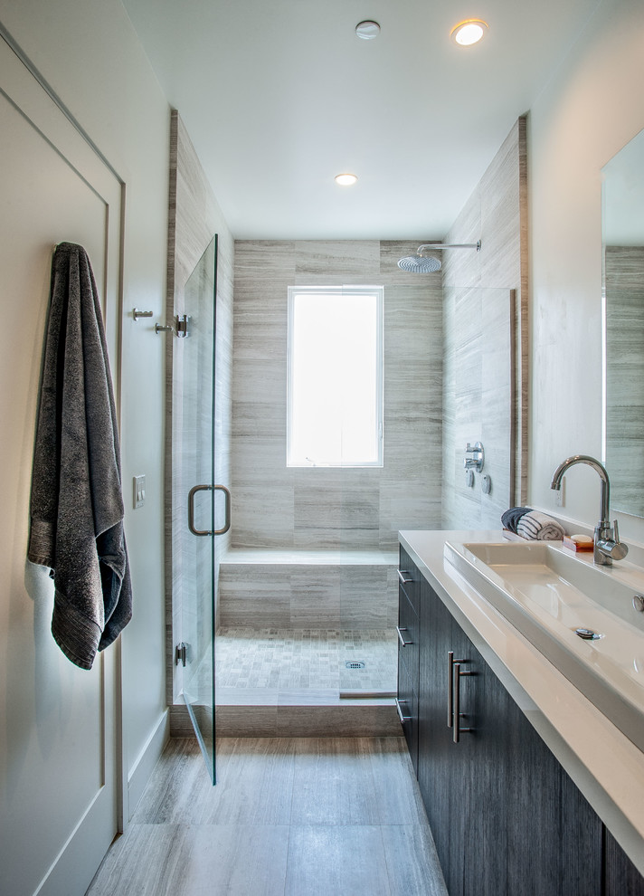 Small minimalist 3/4 gray tile and stone tile limestone floor bathroom photo in Los Angeles with a trough sink, flat-panel cabinets, dark wood cabinets, quartz countertops, a one-piece toilet and white walls