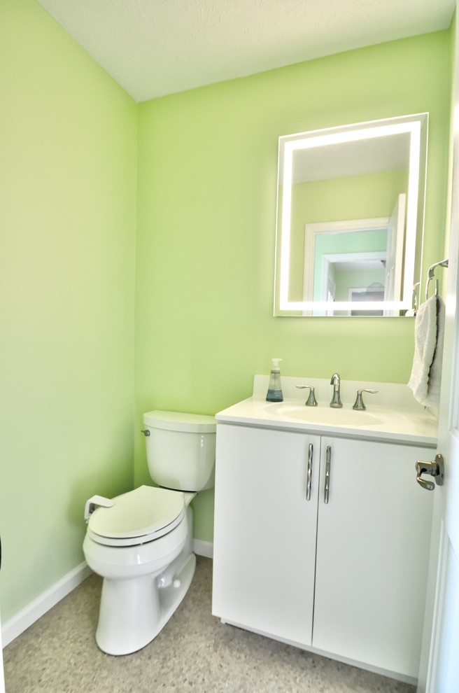 Kleines Modernes Badezimmer mit flächenbündigen Schrankfronten, weißen Schränken, Wandtoilette mit Spülkasten, weißen Fliesen, grüner Wandfarbe, integriertem Waschbecken, Quarzwerkstein-Waschtisch, beigem Boden und weißer Waschtischplatte in Sonstige