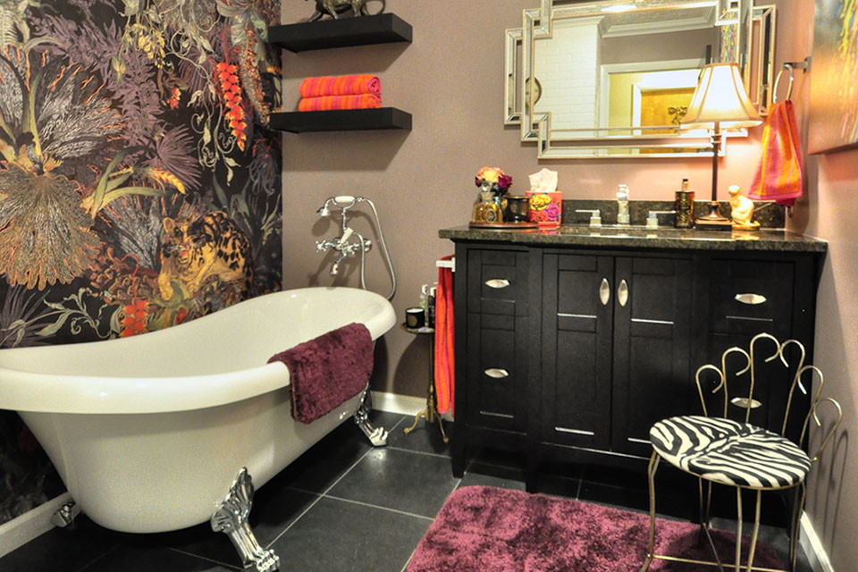 Photo of a medium sized bohemian bathroom with black cabinets, a claw-foot bath, a two-piece toilet, pink walls, vinyl flooring, a submerged sink, granite worktops, black floors and brown worktops.
