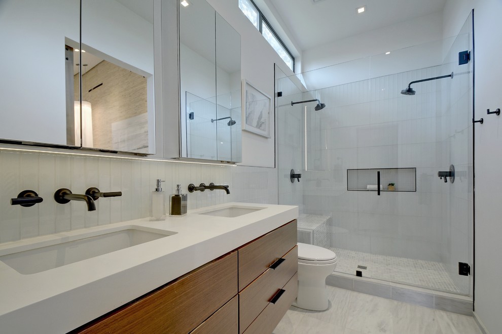 Cette photo montre une salle d'eau tendance avec un placard à porte plane, des portes de placard marrons, une douche double, un carrelage en pâte de verre, un mur blanc, un lavabo encastré, un sol gris, une cabine de douche à porte battante, un plan de toilette blanc, une niche et un banc de douche.