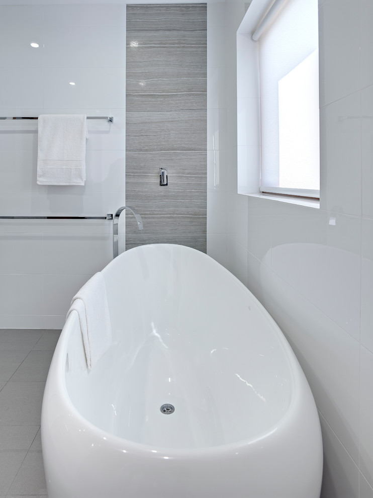 Идея дизайна: главная ванная комната среднего размера в современном стиле с монолитной раковиной, светлыми деревянными фасадами, отдельно стоящей ванной, открытым душем, инсталляцией, серой плиткой, белыми стенами и полом из керамогранита