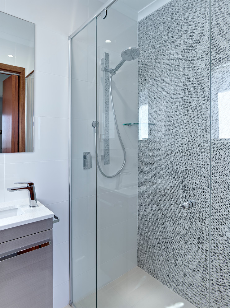 Mittelgroßes Modernes Duschbad mit integriertem Waschbecken, hellen Holzschränken, Eckdusche, Wandtoilette, beigen Fliesen, weißer Wandfarbe und Porzellan-Bodenfliesen in Sonstige