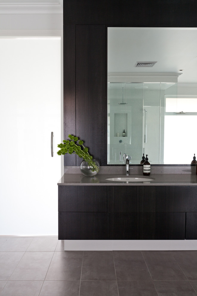 Exemple d'une très grande salle de bain principale tendance avec un lavabo encastré, un placard à porte plane, des portes de placard marrons, un plan de toilette en quartz modifié, une baignoire indépendante, une douche double, un carrelage gris, des carreaux de céramique et un mur blanc.