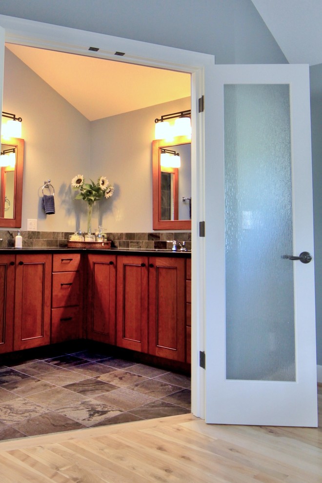 На фото: главная ванная комната среднего размера в классическом стиле с фасадами с декоративным кантом, фасадами цвета дерева среднего тона, душем в нише, раздельным унитазом, разноцветной плиткой, плиткой из сланца, серыми стенами, полом из сланца, врезной раковиной, столешницей из гранита, душем с распашными дверями и черной столешницей