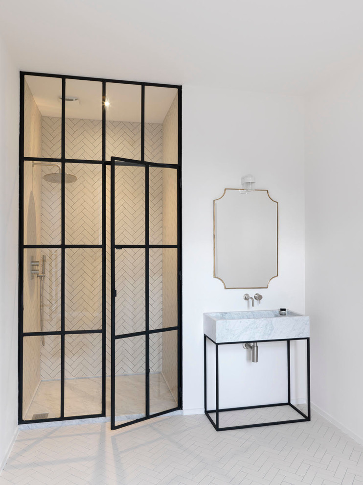 Photo of a contemporary bathroom in London with an alcove shower, white tiles, white walls, a vessel sink and a hinged door.