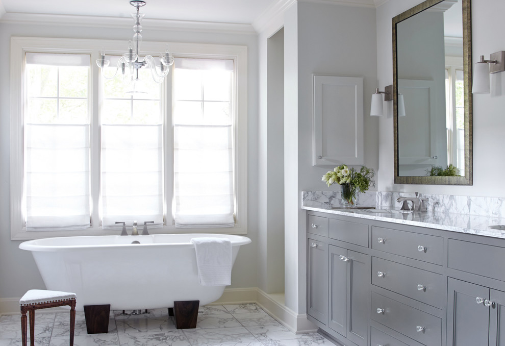 Пример оригинального дизайна: ванная комната в стиле неоклассика (современная классика) с врезной раковиной, фасадами с утопленной филенкой, серыми фасадами, отдельно стоящей ванной, белой плиткой и серыми стенами