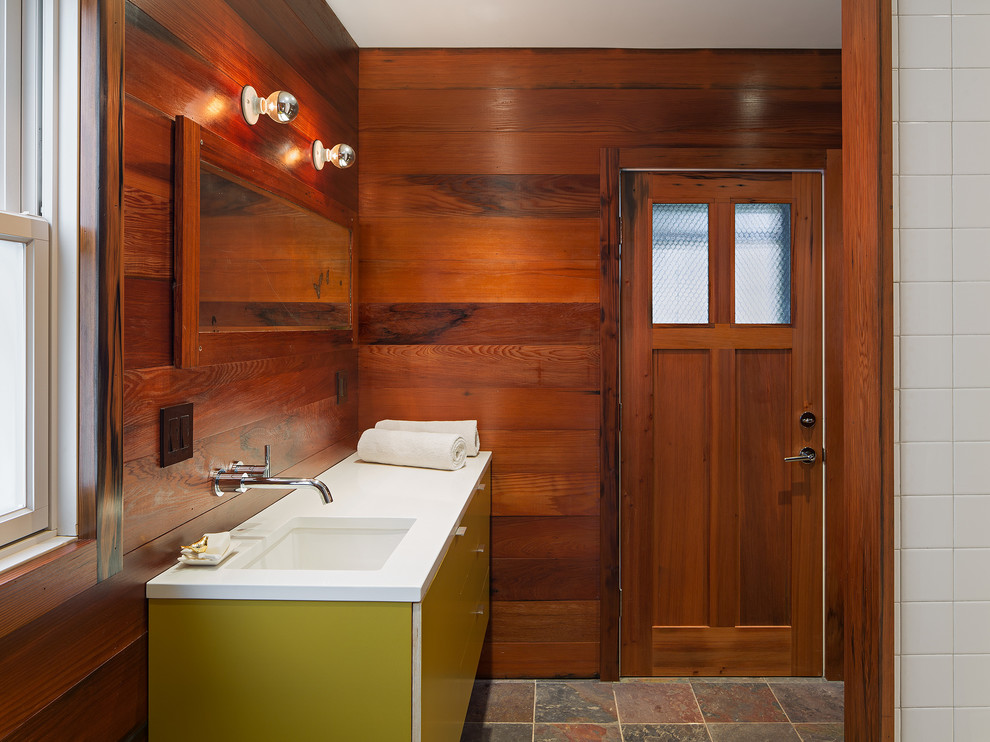 Bild på ett rustikt badrum, med ett undermonterad handfat, släta luckor, gröna skåp och bruna väggar