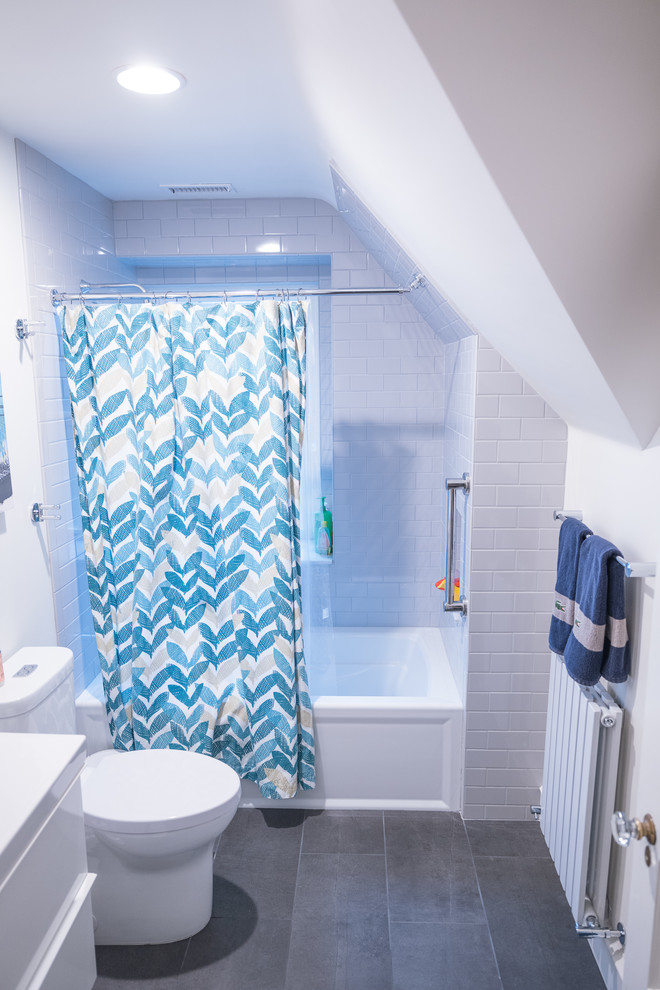 Exempel på ett mellanstort modernt badrum med dusch, med släta luckor, vita skåp, skiffergolv, grått golv, ett badkar i en alkov, en dusch/badkar-kombination, en toalettstol med separat cisternkåpa, vit kakel, tunnelbanekakel, vita väggar, ett integrerad handfat och dusch med duschdraperi