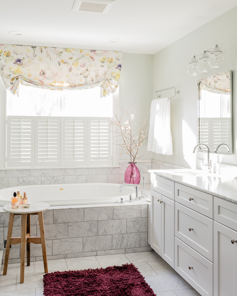 На фото: большая главная ванная комната в классическом стиле с фасадами в стиле шейкер, белыми фасадами, накладной ванной, белой плиткой, белыми стенами, врезной раковиной, белым полом, мраморной плиткой и зеркалом с подсветкой с