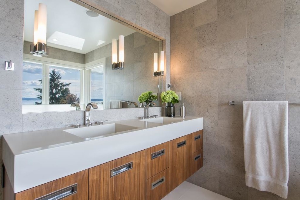Contemporary ensuite bathroom in Seattle with a built-in sink, flat-panel cabinets, medium wood cabinets, solid surface worktops and grey tiles.