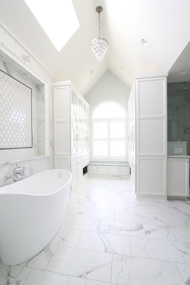Пример оригинального дизайна: огромная главная ванная комната в стиле неоклассика (современная классика) с фасадами с утопленной филенкой, белыми фасадами, отдельно стоящей ванной, белой плиткой, мраморным полом, керамической плиткой и синими стенами