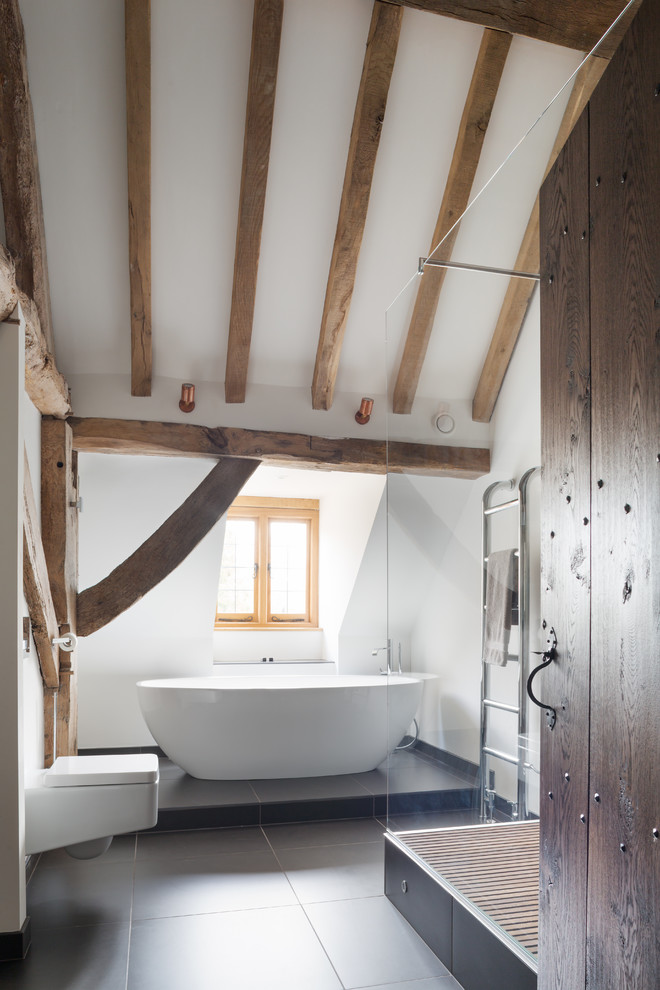 На фото: ванная комната в стиле рустика с отдельно стоящей ванной, инсталляцией, желтыми стенами, консольной раковиной и открытым душем
