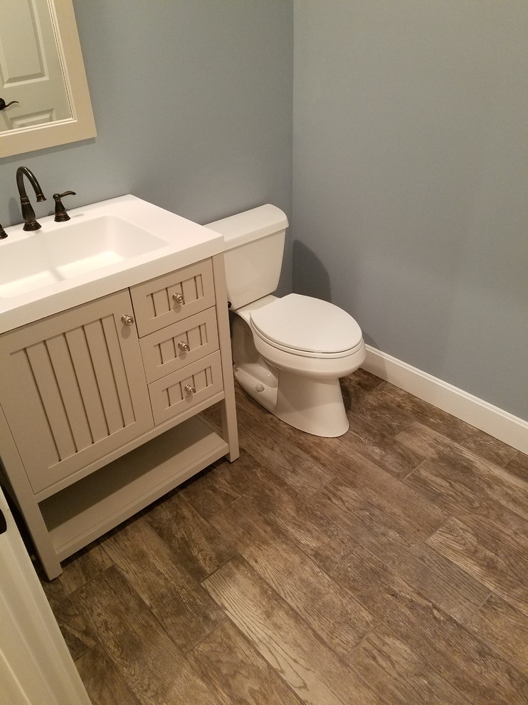 Exempel på ett litet klassiskt badrum, med möbel-liknande, beige skåp, en toalettstol med separat cisternkåpa, keramikplattor, blå väggar, klinkergolv i keramik och bänkskiva i akrylsten