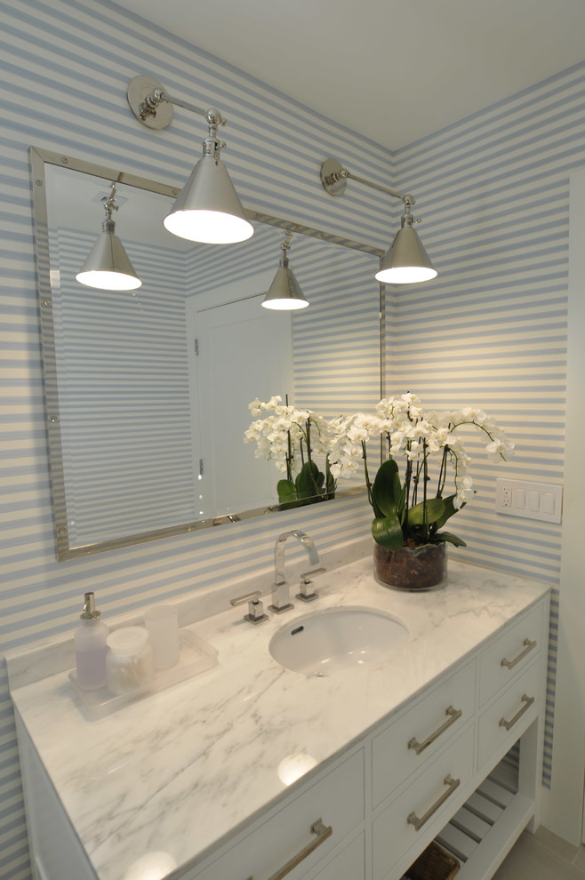 Exempel på ett mellanstort klassiskt badrum med dusch, med släta luckor, vita skåp, en dusch i en alkov, en toalettstol med hel cisternkåpa, svart och vit kakel, stenhäll, vita väggar, klinkergolv i keramik, ett undermonterad handfat och marmorbänkskiva