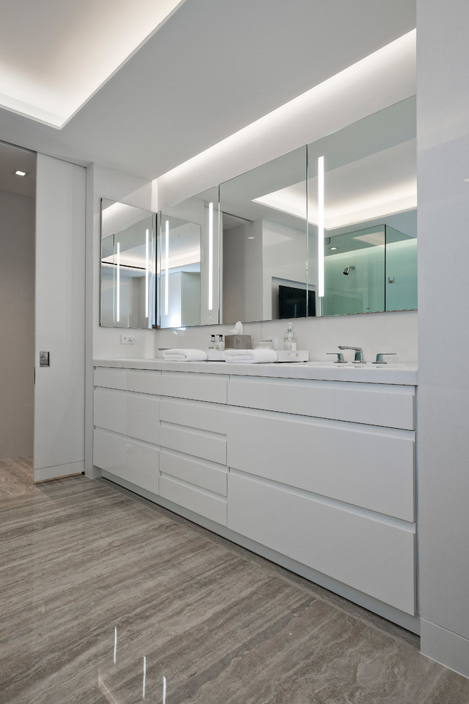 Cette image montre une salle de bain principale minimaliste de taille moyenne avec un placard à porte plane, des portes de placard blanches, un mur blanc, un lavabo encastré, un plan de toilette en quartz modifié, un sol marron et un plan de toilette blanc.