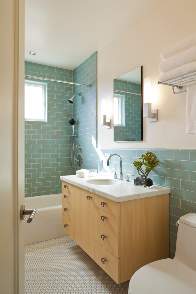 Diseño de cuarto de baño moderno con encimera de mármol y combinación de ducha y bañera