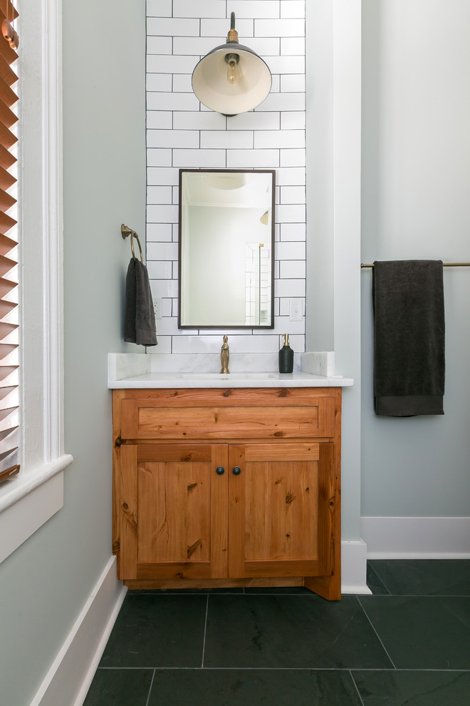 Inspiration for a mid-sized craftsman 3/4 black and white tile corner shower remodel in Charleston with shaker cabinets, white cabinets, a one-piece toilet, white walls and an undermount sink