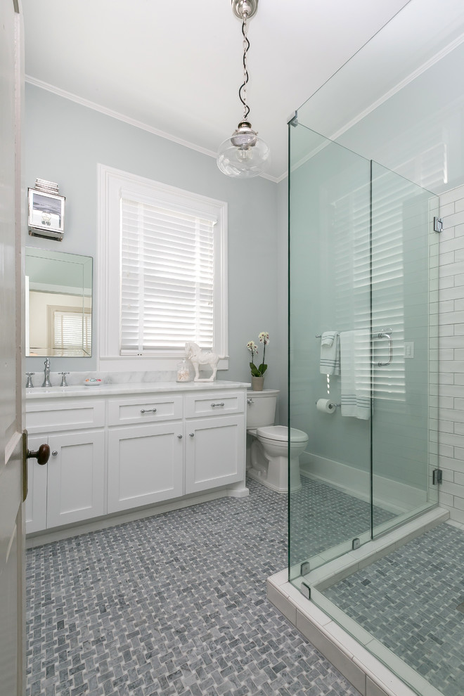 Corner shower - mid-sized craftsman master corner shower idea in Charleston with shaker cabinets, white cabinets, a one-piece toilet, white walls and an undermount sink