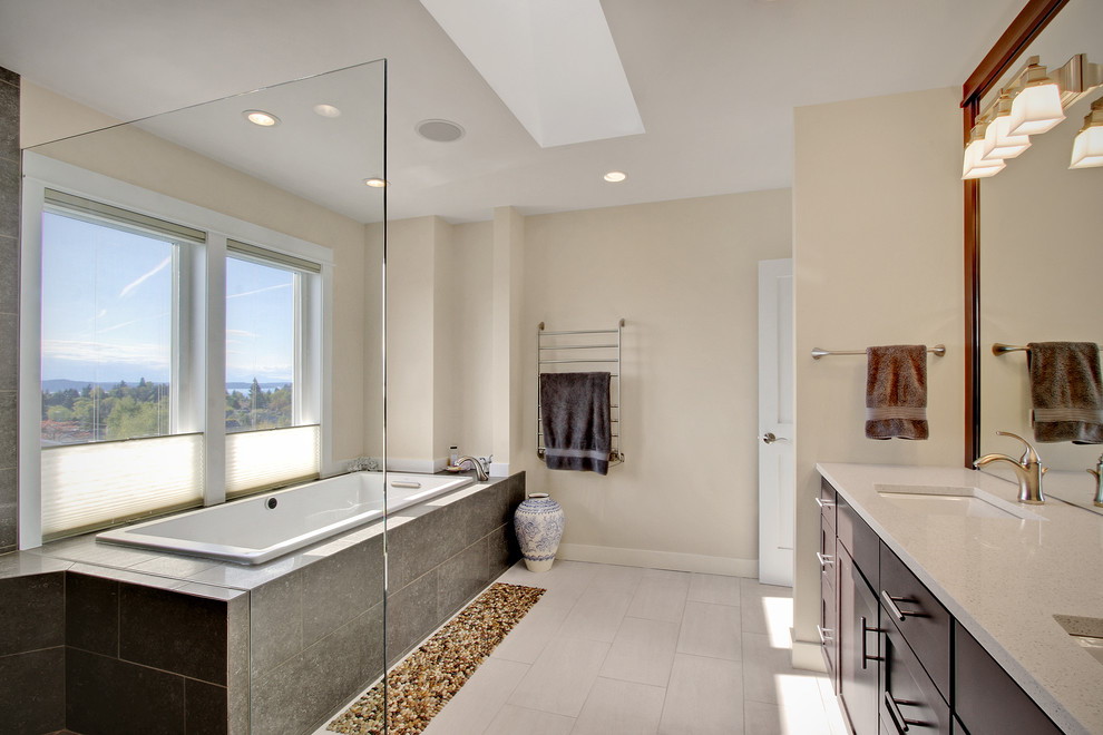 Example of a large arts and crafts master gray tile and stone tile porcelain tile bathroom design in Seattle with an undermount sink, recessed-panel cabinets, dark wood cabinets, quartz countertops, a two-piece toilet and beige walls