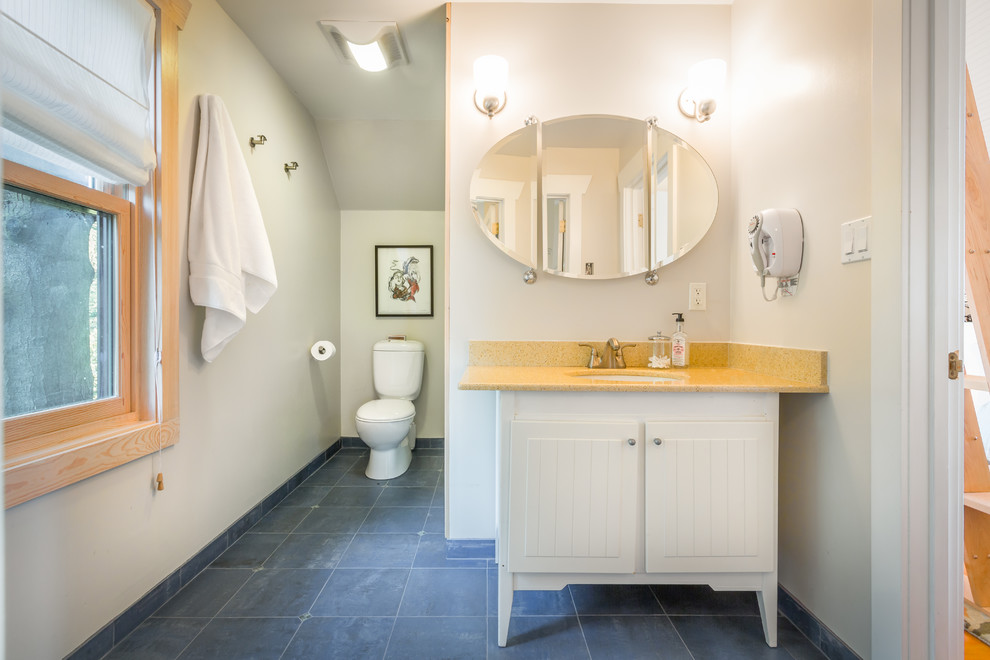 На фото: ванная комната в морском стиле с врезной раковиной, белыми фасадами, синим полом и плоскими фасадами