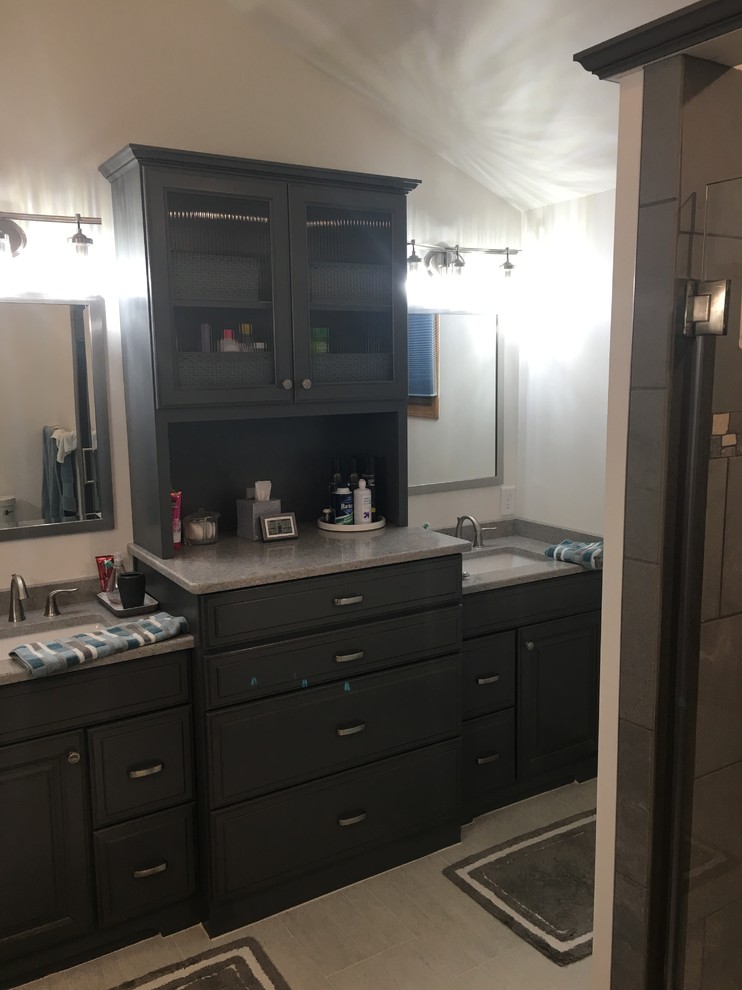 Example of a large transitional master gray tile and porcelain tile porcelain tile and beige floor alcove shower design in New York with furniture-like cabinets, gray cabinets, a two-piece toilet, beige walls, an undermount sink, quartz countertops, a hinged shower door and gray countertops