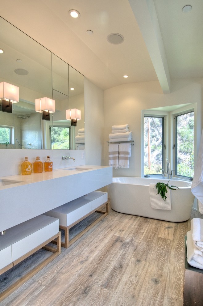 На фото: ванная комната: освещение в стиле модернизм с отдельно стоящей ванной