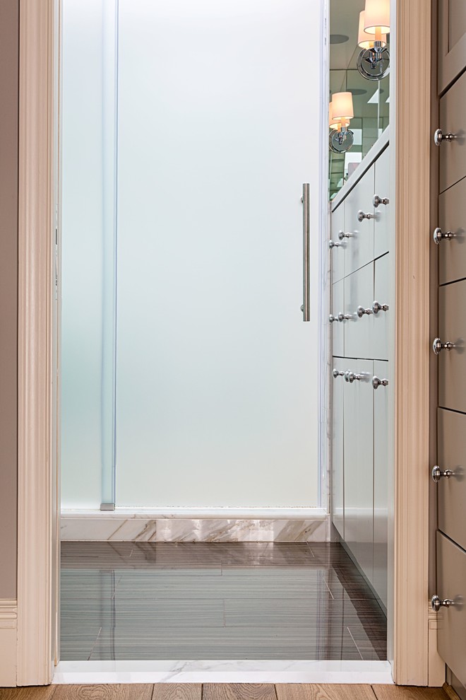 Exemple d'une petite salle de bain moderne avec un placard à porte plane, des portes de placard grises, un carrelage blanc, un carrelage de pierre, un lavabo de ferme, un mur gris, un sol en marbre, une douche ouverte et WC suspendus.