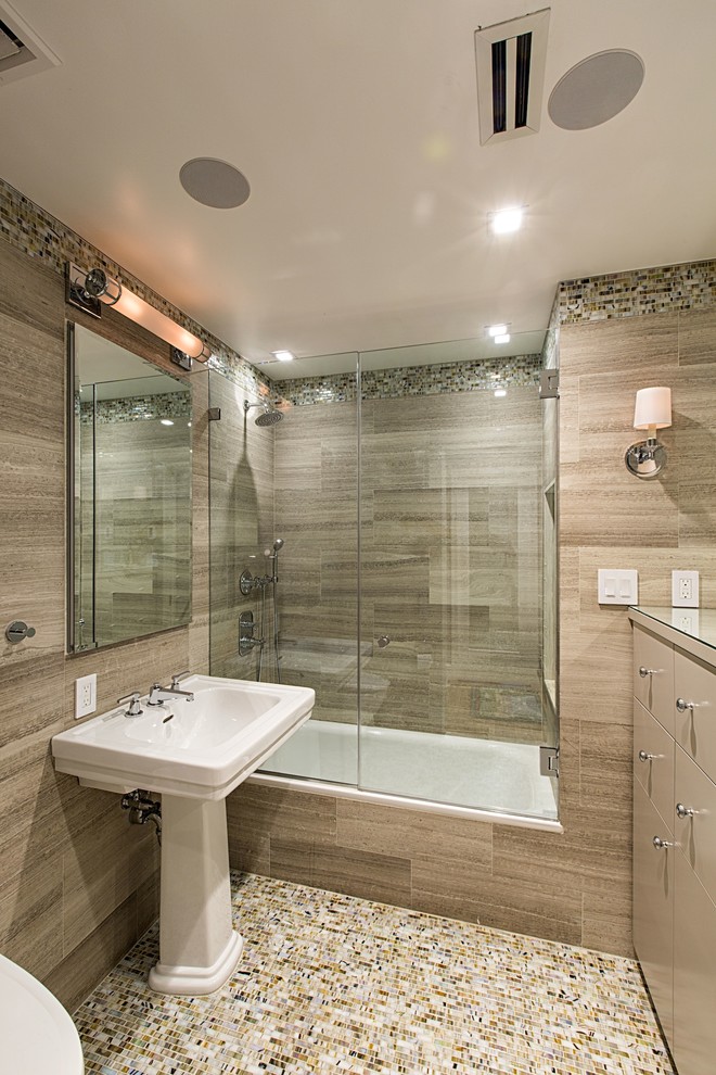 Contemporary bathroom in New York with flat-panel cabinets, beige cabinets, beige tiles, mosaic tiles, beige walls, a pedestal sink and a built-in bath.