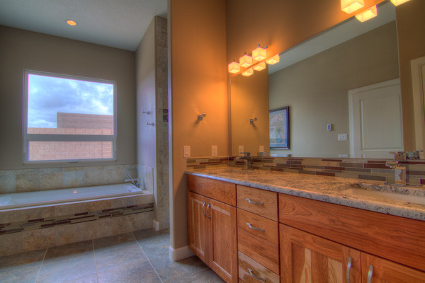 Bild på ett mellanstort vintage en-suite badrum, med ett undermonterad handfat, skåp i shakerstil, skåp i mellenmörkt trä, granitbänkskiva, ett platsbyggt badkar, en dusch i en alkov, flerfärgad kakel, keramikplattor, beige väggar och klinkergolv i keramik