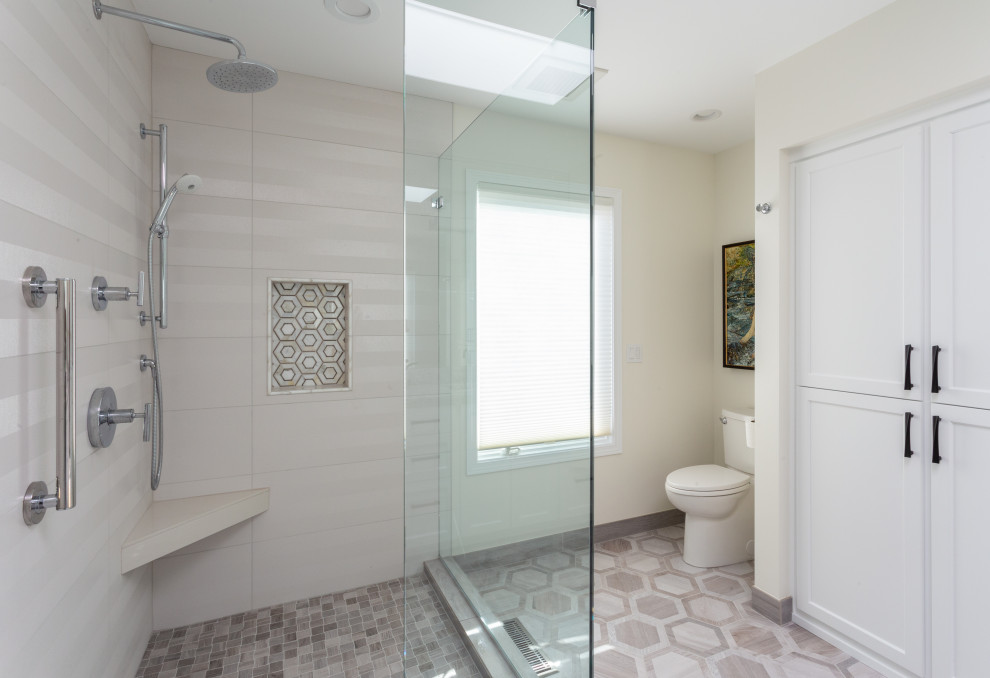 This is an example of an ensuite bathroom in Portland with recessed-panel cabinets, white cabinets, a corner shower, a one-piece toilet, white tiles, white walls, cement flooring, marble worktops, multi-coloured floors, a hinged door, multi-coloured worktops, double sinks and a built in vanity unit.