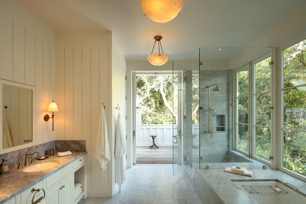 Expansive rural ensuite bathroom in San Francisco with recessed-panel cabinets, white cabinets, a corner shower, a submerged sink, marble worktops, a submerged bath, grey tiles, white walls, mosaic tile flooring and a hinged door.