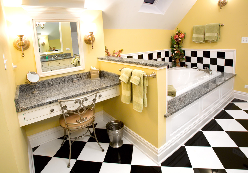 Cette photo montre une salle de bain grise et jaune éclectique avec des portes de placard blanches, une baignoire posée, un carrelage multicolore, un mur jaune, un plan de toilette gris et du carrelage bicolore.