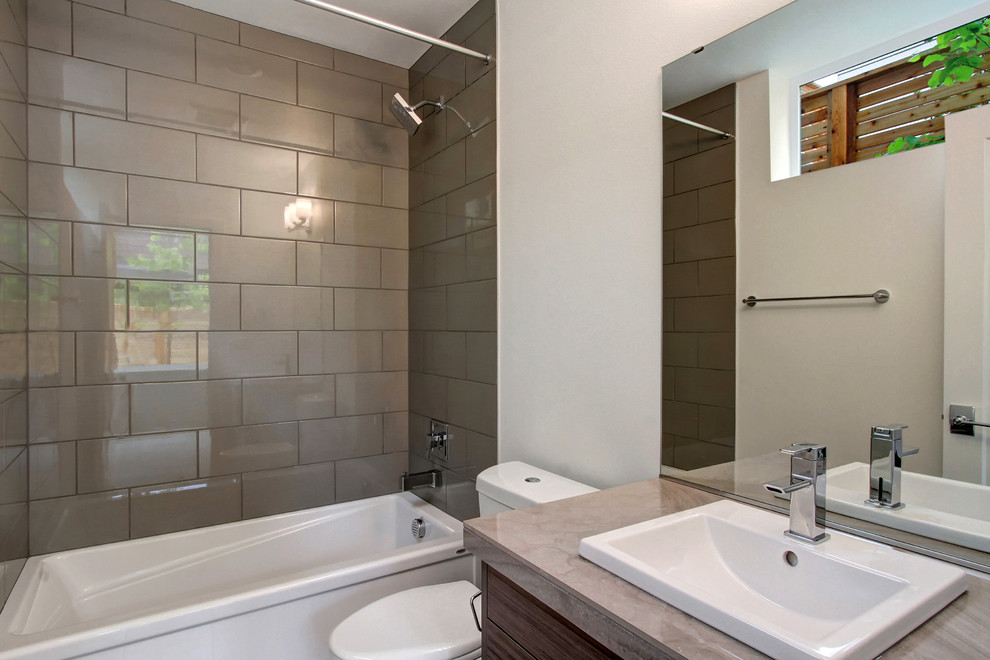 Свежая идея для дизайна: главная ванная комната среднего размера в современном стиле с плоскими фасадами, фасадами цвета дерева среднего тона, душем над ванной, серой плиткой, белыми стенами, столешницей из плитки и шторкой для ванной - отличное фото интерьера