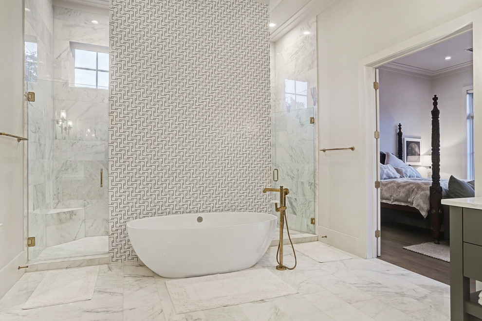 This is an example of an expansive classic ensuite bathroom in Houston with flat-panel cabinets, grey cabinets, a freestanding bath, a double shower, a one-piece toilet, white tiles, marble tiles, white walls, marble flooring, a built-in sink, engineered stone worktops, white floors, an open shower and grey worktops.