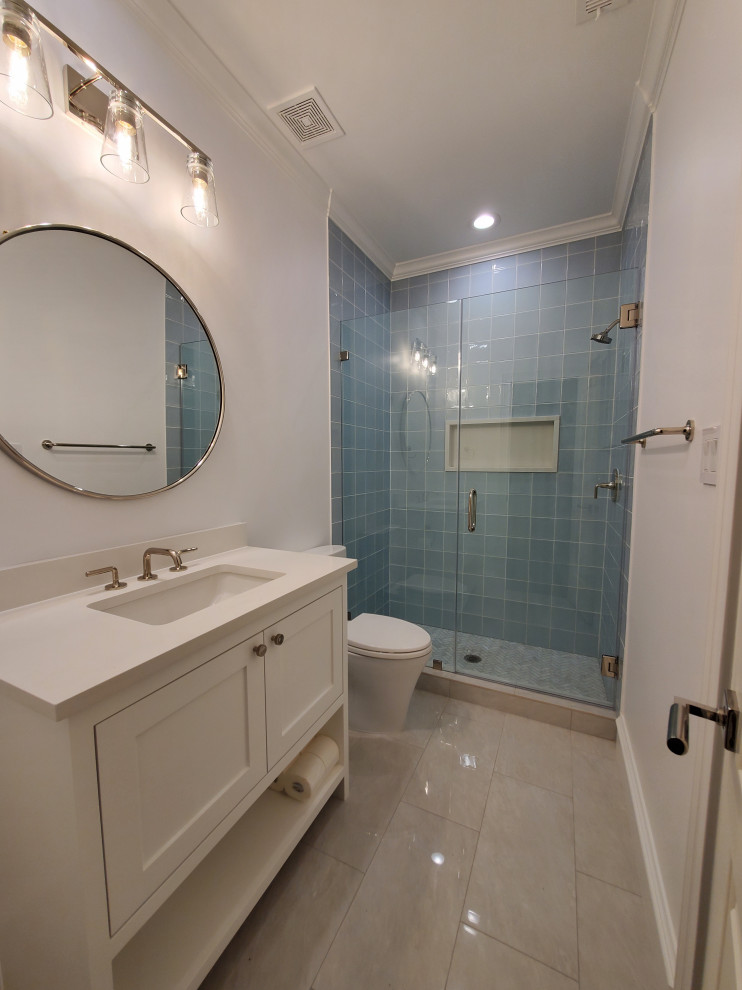 Example of a mid-sized classic kids' blue tile and glass sheet marble floor, multicolored floor and single-sink bathroom design in Houston with shaker cabinets, white cabinets, a one-piece toilet, white walls, a drop-in sink, quartzite countertops, white countertops and a built-in vanity