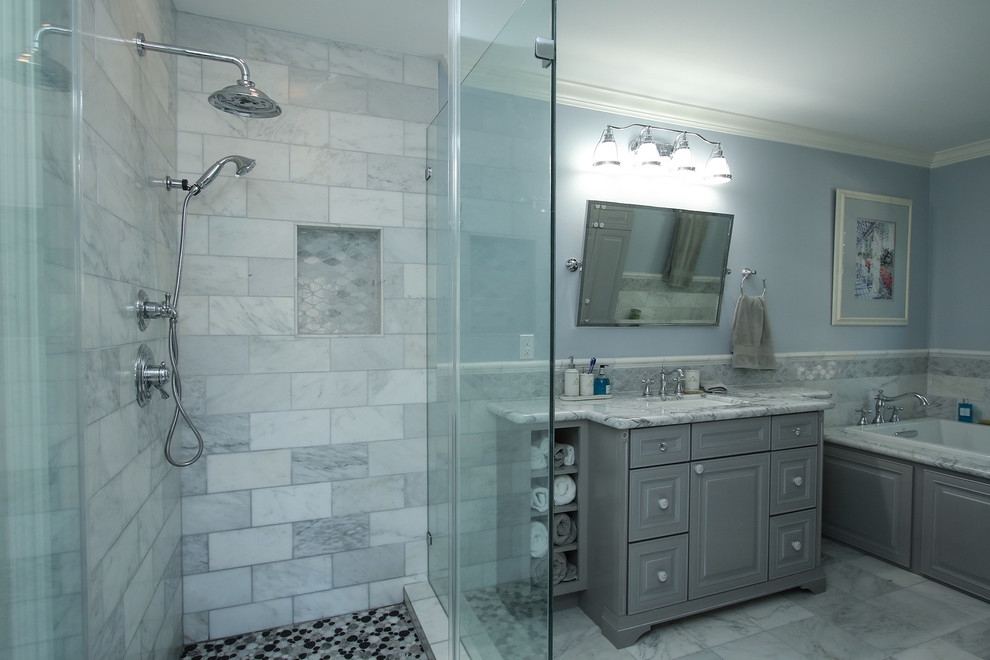 Inredning av ett klassiskt stort en-suite badrum, med luckor med upphöjd panel, grå skåp, ett platsbyggt badkar, stenkakel, blå väggar, marmorgolv, ett undermonterad handfat och marmorbänkskiva