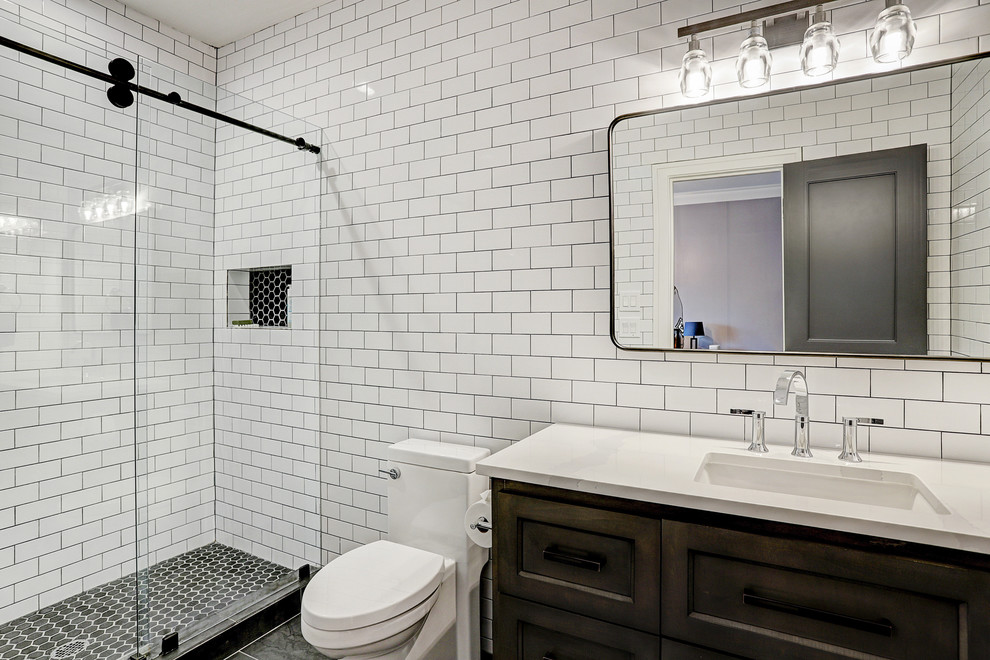 Idéer för ett mellanstort klassiskt vit badrum med dusch, med luckor med infälld panel, bruna skåp, en hörndusch, en toalettstol med hel cisternkåpa, vit kakel, marmorkakel, vita väggar, klinkergolv i keramik, ett nedsänkt handfat, bänkskiva i kvartsit och grått golv