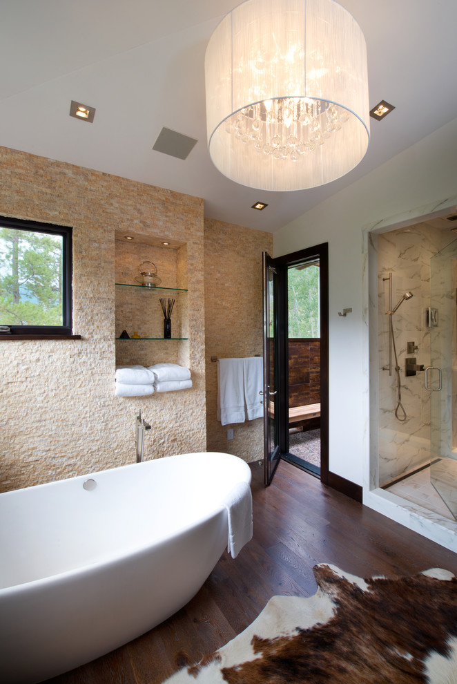 Inredning av ett rustikt stort en-suite badrum, med ett fristående badkar, en dusch i en alkov, beige kakel, stenkakel, vita väggar, mörkt trägolv, släta luckor, skåp i mörkt trä och granitbänkskiva