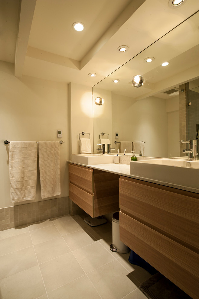 Mid-sized mid-century modern 3/4 white tile and ceramic tile ceramic tile walk-in shower photo in Vancouver with a vessel sink, flat-panel cabinets, medium tone wood cabinets, quartz countertops, a two-piece toilet and white walls
