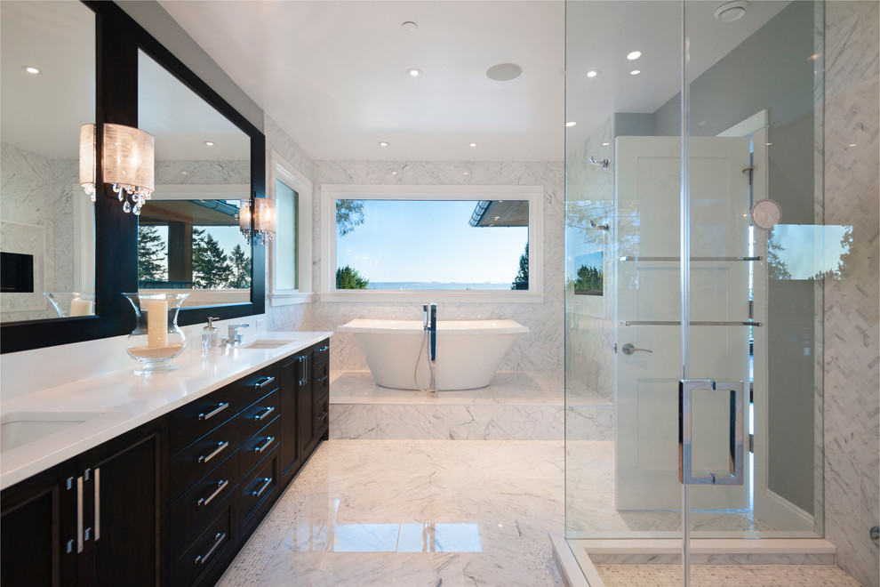 Inspiration for a large transitional master white tile and stone tile marble floor freestanding bathtub remodel in Vancouver with an undermount sink, shaker cabinets, dark wood cabinets, marble countertops, a two-piece toilet and blue walls