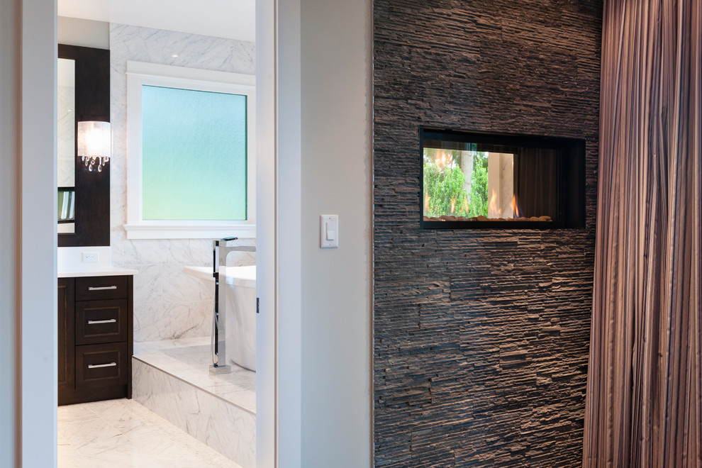 Large transitional master white tile and stone tile marble floor freestanding bathtub photo in Vancouver with an undermount sink, shaker cabinets, dark wood cabinets, marble countertops, a two-piece toilet and blue walls