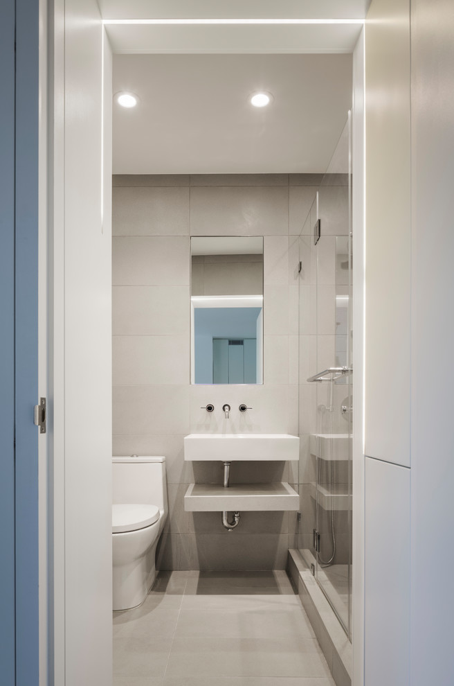 Пример оригинального дизайна: маленькая главная ванная комната в стиле модернизм с плоскими фасадами, белыми фасадами, унитазом-моноблоком, серой плиткой, серыми стенами, бетонным полом, подвесной раковиной, столешницей из бетона и серым полом для на участке и в саду
