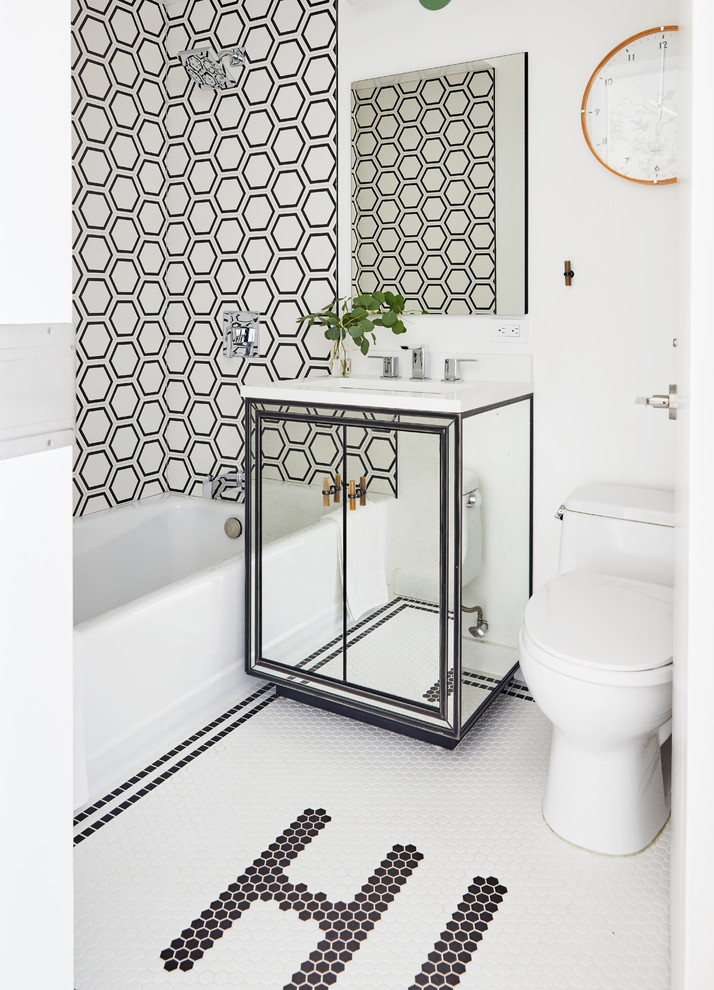 На фото: ванная комната в современном стиле с плоскими фасадами, накладной ванной, душем над ванной, черно-белой плиткой, белыми стенами, полом из мозаичной плитки, врезной раковиной, белым полом и белой столешницей с