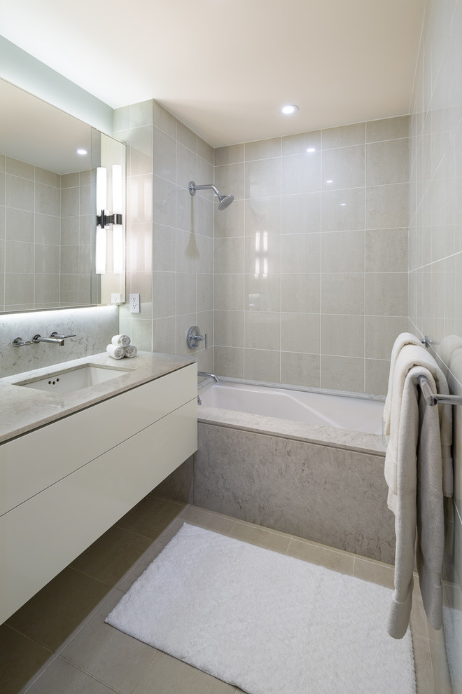 Exempel på ett mellanstort modernt en-suite badrum, med släta luckor, ett undermonterat badkar, ett undermonterad handfat och bänkskiva i kvarts