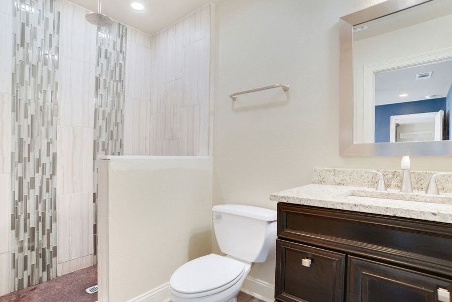 Small transitional white tile and glass tile ceramic tile and beige floor bathroom photo in New Orleans with recessed-panel cabinets, dark wood cabinets, a two-piece toilet, white walls, an undermount sink and granite countertops