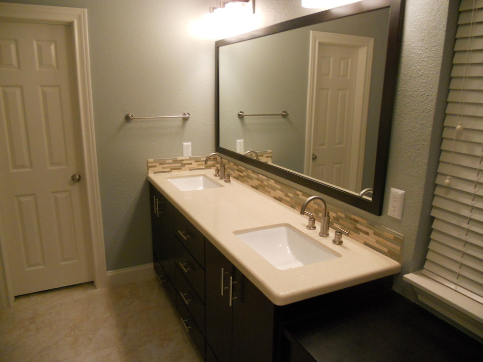 This is an example of a medium sized classic ensuite bathroom in Austin with flat-panel cabinets, brown cabinets, beige tiles, blue tiles, brown tiles, matchstick tiles, blue walls, travertine flooring, a submerged sink, solid surface worktops and beige floors.