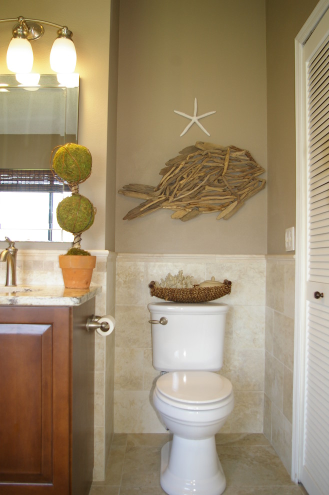 Aménagement d'une salle de bain principale bord de mer en bois brun de taille moyenne avec une baignoire posée, une douche d'angle, WC séparés, un carrelage beige, des carreaux de porcelaine, un mur beige, un lavabo encastré et un plan de toilette en granite.