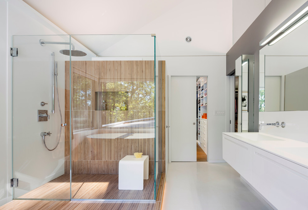 Photo of a large modern ensuite bathroom in San Francisco with flat-panel cabinets, white cabinets, a built-in shower, white tiles, white walls, a hinged door and white floors.