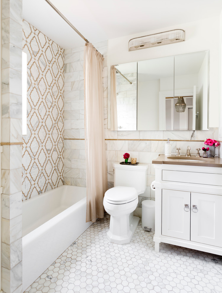 Design ideas for a medium sized traditional bathroom in New York with shaker cabinets, white cabinets, an alcove bath, a shower/bath combination, brown tiles, grey tiles, white tiles, stone tiles, white walls, marble flooring and a submerged sink.